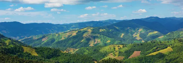 Green hilly landscape view with blue sky